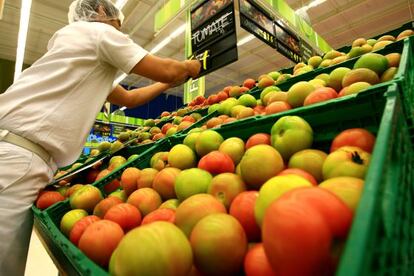 Funcion&aacute;rio corrige o pre&ccedil;o do tomate em um supermercado.