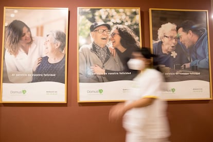 Una trabajadora pasa frente a unos posters promocionales de la residencia DomusVi Arutro Soria.