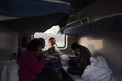 Un grupo de viajeros comen en su coche cama durante el viaje a Chengdu.
