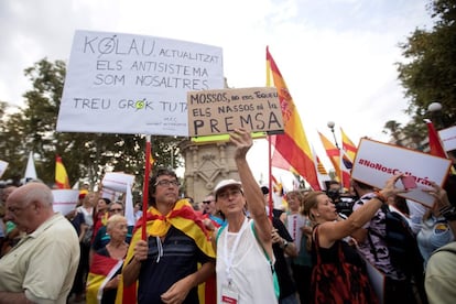 Una mujer muestra una pancarta que lee "Mossos, no nos toquéis las narices ni la prensa".