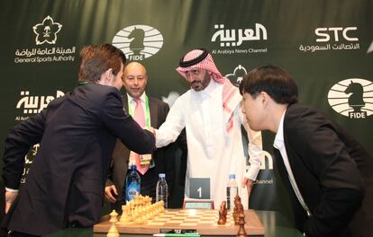 Magnus Carlsen recibe el saludo de una autoridad saudí durante el saque de honor antes de disputar la primera ronda ante le chino Bu, que le ganó.