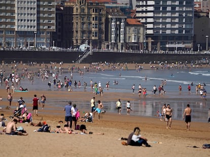 Cientos de personas disfrutan de un día soleado en la playa de San Lorenzo de Gijón, a mediodía del pasado sábado.