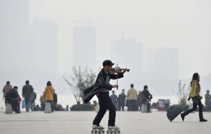 Un hombre toca el violín mientas monta en patines en Nanjing, provincia de Jiangsu (China), 5 de diciembre 2013.