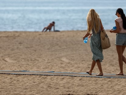 Dos mujeres paseaban a primeras horas de esta mañana por la playa de la Malvarrosa, en Valencia,