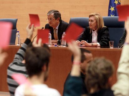 Varios estudiantes muestran tarjetas rojas a Rosa Díez, sentada junto al profesor Rafael Calduch.
