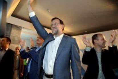 El presidente del Gobierno y del PP, Mariano Rajoy (c), junto al cabeza de lista de su partido por Ourense en los comicios autonómicos gallegos, Jesús Vázquez (dcha), durante la clausura de un acto de los populares en la precampaña electoral.