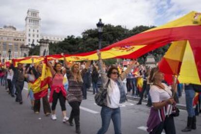 Un grupo de manifestantes elevan una bandera española