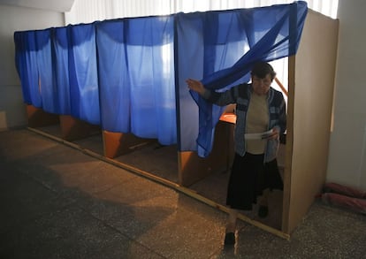 Uma mulher sai de uma cabine de votação em um colégio da cidade de Slaviansk, no leste da Ucrânia.