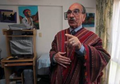 Fotografía que muestra al profesor boliviano Oscar Barriga, un investigador que ha consagrado 40 años de su vida a conocer el arte de los ponchos tejidos por indígenas aimaras y quechuas, mientras habla durante una entrevista con una elegante pieza denominada "Pankhochi" que tiene 2300 figuras asociadas a la vida en el campo, en La Paz (Bolivia).