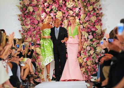 De la Renta acompañado de las modelos Karlie Kloss, izquierda, y Daria Strokous, derecha, después de presentar su colección de primavera 2015 en la Semana de la Moda en Nueva York, la última del malogrado diseñador al que se le diagnosticó un cáncer en 2006. El diseñador lanzó su primera colección bajo su propio nombre en 1965. Dos años antes, había entrado a trabajar como diseñador en Elizabeth Arden gracias a una recomendación de Diana Vreeland.