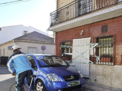 Un vecino observa la vivienda precintada de la calle Tarragona de Armilla (Granada) tras el asesinato de un hombre.