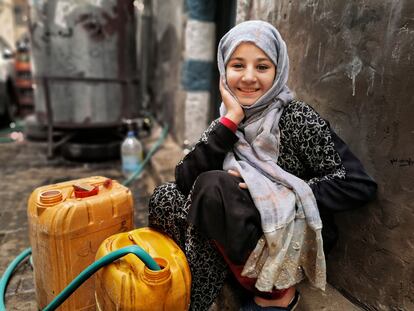 Una niña yemení consigue agua en bidones en un punto de abastecimiento.