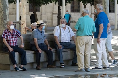Un grupo de jubilados en un banco de un parque de Sevilla en septiembre de 2020.