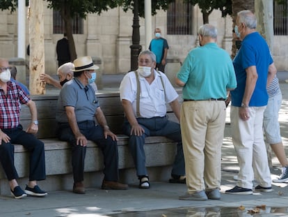 Un grupo de jubilados en un banco de un parque de Sevilla en septiembre de 2020.