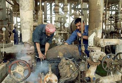 Dos trabajadores iraquíes reparan en mayo de 2003 la refinería de Al Daura, cerca de Bagdad.