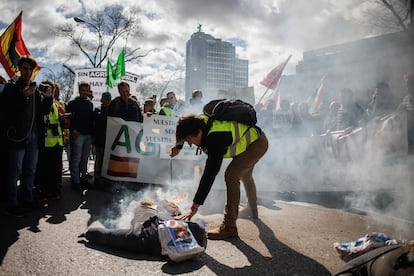 Un agricultor raja un muñeco de paja con la cara de Pedro Sánchez, durante la manifestación de agricultores celebrada este lunes en Madrid.