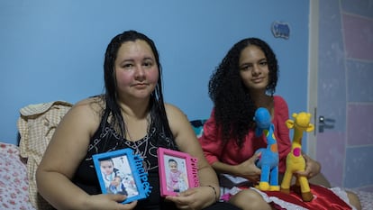 Mayra Pires Lima, de 38 anos, ao lado da sobrinha Evelyn, de 15 anos. Elas seguram as fotos, roupas e brinquedos do casal de bebês Gabriel e Sophia. As crianças ficaram órfãs após a morte da mãe por covid-19. Mayra ficou com a guarda de todos os sobrinhos.