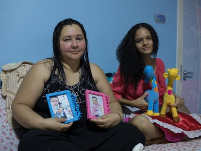 Mayra Pires Lima, de 38 anos, ao lado da sobrinha Evelyn, de 15 anos. Elas seguram as fotos, roupas e brinquedos do casal de bebês Gabriel e Sophia. As crianças ficaram órfãs após a morte da mãe por covid-19. Mayra ficou com a guarda de todos os sobrinhos.