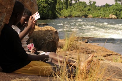 Después de lavar la ropa, Amaiduna (14) y Graciella (13) pasan el tiempo jugando a las cartas. Son vacaciones. Delante, el nacimiento del Nilo en todo su esplendor, haciendo gala de ser el río más largo del mundo con más de 6.000 kilómetros de longitud.