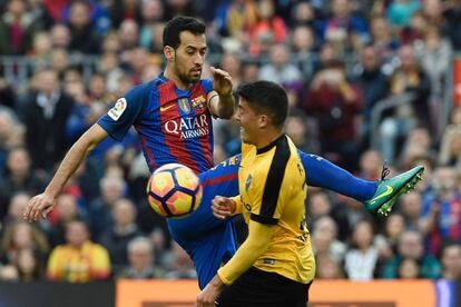 Sergio Busquets (izquierda) del Barcelona después de golpear el balón frente a Pablo Fornals del Málaga.