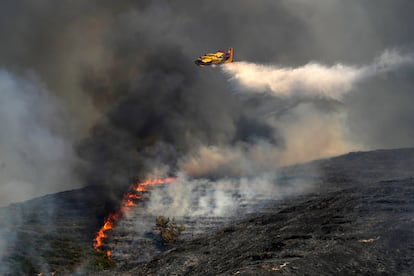 Un avión deja caer agua sobre un incendio forestal en el pueblo de Vati, en la isla griega de Rodas.