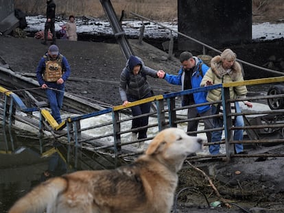 En su huida de los combates, varias personas cruzan el puente sobre el río Irpin, volado por el Ejército Ucranio para tratar de evitar la llegada de tropas rusas a Kiev.