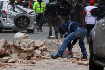 La ciudad de Cuenca, que está en la zona andina, es una de las más afectadas. En la imagen, un voluntario recoge los escombros de un edificio, en Cuenca.