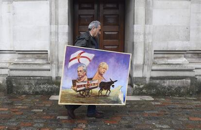 El artista Kaya Mar sostiene una de sus obras en las que representa al líder del euroescéptico y eurófobo UKIP, Nigel Farage (i), y al exalcalde de Londres y líder oficioso de la campaña por el "brexit", Boris Johnson, en Londres.