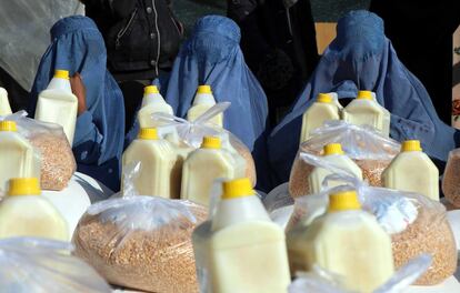 Tres mujeres cubiertas con burkas reciben ayuda humanitaria enviada por el Programa Mundial de Alimentos (WFP) en Herat (Afganistán). Más de siete mil familias afganas se benefician de este programa.
