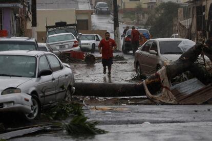 Un hombre corre por una calle de Guayama, entre coches destrozados por la fuerza con la que el huracán María atravesó Puerto Rico.