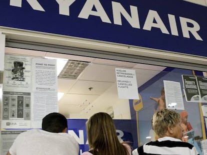 Pasajeros afectados por la huelga de Ryanair hacen cola frente a un mostrador de la compañía.