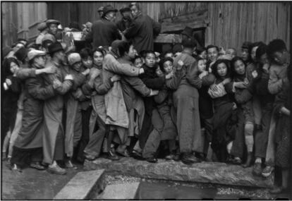 Multidão esperando diante de um banco para comprar ouro durante os últimos dias do Kuomintang, (Shangai, dezembro de 1948). Enquanto baixava o valor do dinheiro, o Kuomintang decidiu distribuir 40 gramas de ouro por pessoa. Em dezembro de 49, milhares saíram às ruas para esperar durante horas sua parte de riqueza. A polícia, equipada com os restos das armas do Assentamento Internacional, fez um gesto claro para manter o poder: dez pessoas foram esmagadas até a morte.