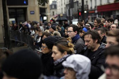 Un grupo de personas asiste al homenaje a las víctimas cerca de la sala de conciertos 'Bataclan' en París.