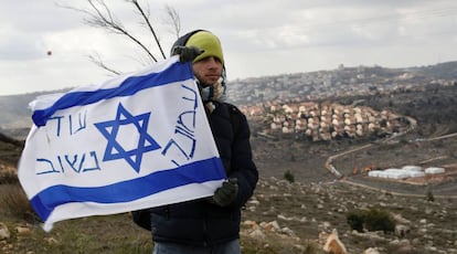 Un colono jud&iacute;o con una bandera isarel&iacute; en el asentamiento de Amona en Cisjordania.