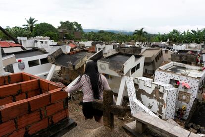Una mujer mira los escombros del cementerio de Piojó, destruido en gran parte después de horas de fuertes lluvias que, según las autoridades, provocaron un deslizamiento de tierra debido a una falla geológica.