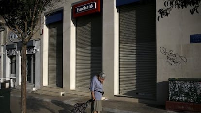 Una mujer pasa delante de una sucursal bancaria cerrada, el lunes en Atenas. 