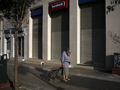 Una mujer pasa delante de una sucursal bancaria cerrada, el lunes en Atenas. 