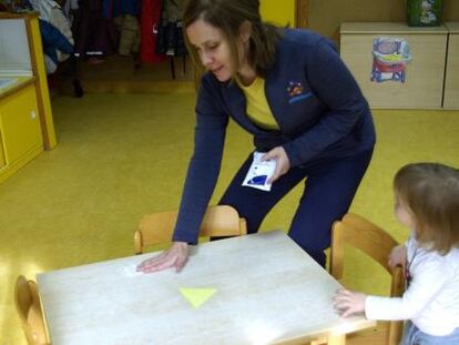 Una educadora del Colegio Pasacalles de Algete (Madrid) limpia una mesa con toallitas impregnadas.