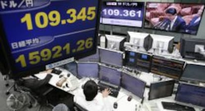 Empleados en el Nikkei con el presidente Shinzo Abe en los monitores.