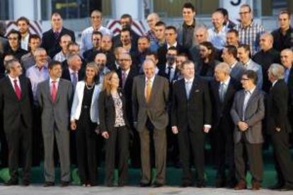 El Rey Juan Carlos (5º d primera fila) posa en la foto de familia con los trabajadores del Tercat tras la inauguración en Barcelona de la nueva terminal de contenedores del grupo chino Hutchinson, con la ministra de Fomento, Ana Pastor (primera fila 4ª i); la delegada del Gobierno en Cataluña, María de los Llanos de Luna (primera fila 3ª i); el director ejecutivo para Europa de Hutchinson, Clemence Cheng, (3º d primera fila); el alcalde de Barcelona, Xavier Trias (primera fila 1º d) y el director ejecutivo de Hutchinson Port, John Meredith, (primera fila 4º d) entre otras personalidades.