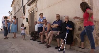 Tertulia en una de las calles de Olmeda de la Cuesta, donde solo hay 15 vecinos fijos todo el a&ntilde;o. Con muletas, Flora Vergara, de 88 a&ntilde;os, una de las veteranas.