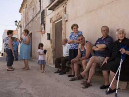 Tertulia en una de las calles de Olmeda de la Cuesta, donde solo hay 15 vecinos fijos todo el a&ntilde;o. Con muletas, Flora Vergara, de 88 a&ntilde;os, una de las veteranas.