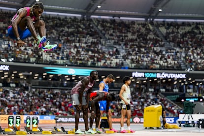 Noah Lyles, a la izquierda, calienta con un salto antes de la salida de los 100m.