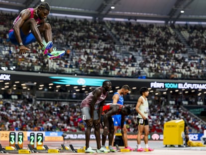 Noah Lyles, a la izquierda, calienta con un salto antes de la salida de los 100m.