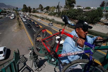 Hombres cargan sus bicicletas por un puente peatonal en Ecatepec, municipio conurbado de Ciudad de México, en 2016.