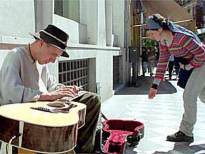 Eric Mongrain, en plena calle, tocando su guitarra acústica de una forma peculiar.