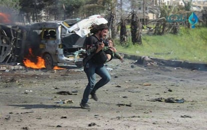 El fotógrafo Abd Alkader corre con un niño en brazos tras el atentado terrorista.