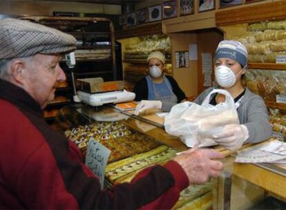 Dos dependientas atienden con mascarilla en una panadería-pastelería de Quilmes, en la provincia de Buenos Aires