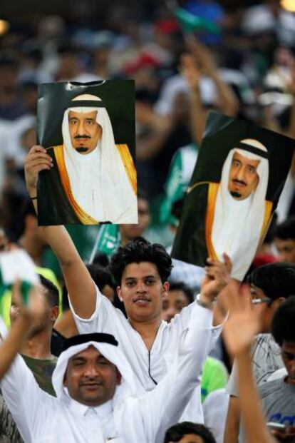 Seguidores de Arabia Saud&iacute; sostienen fotos del rey Salman bin Abdulaziz durante un partido de f&uacute;tbol en Yeda.