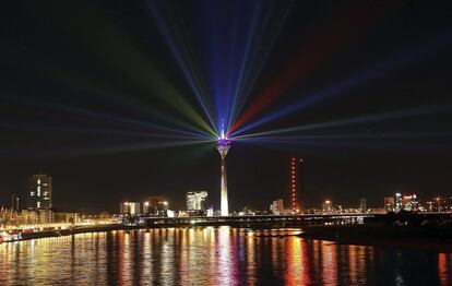 El edificio Rheinturm (Rhine Tower) mientras ilumina el cielo con luces de colores durante el 70º aniversario del estado alemán de Renania del Norte-Westfalia, en Dusseldorf (Alemania).